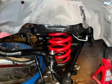 What a pain in the butt to install the springs. Ended up removing the control arms and using it in the equation to compress the springs. Reinstalled the control arms with springs not fully seated in the pocket of the cross member. 

A ratchet strap attached to a coil and to a point on the opposite side of the cross member for the seated correctly. 