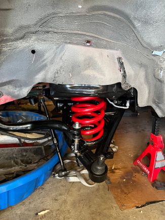What a pain in the butt to install the springs. Ended up removing the control arms and using it in the equation to compress the springs. Reinstalled the control arms with springs not fully seated in the pocket of the cross member. 

A ratchet strap attached to a coil and to a point on the opposite side of the cross member for the seated correctly. 
