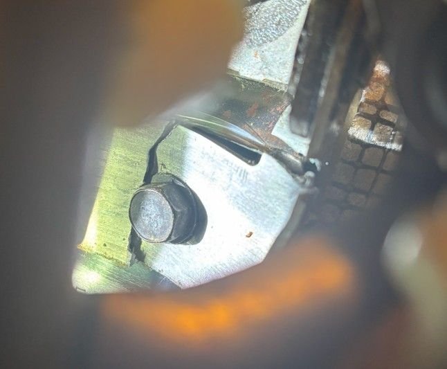 same bolt, other side.  The crack is in two places.  Parallel to the seat and then it twisted away from the rest of the bracket.  The piece still under the bult is severely bent.