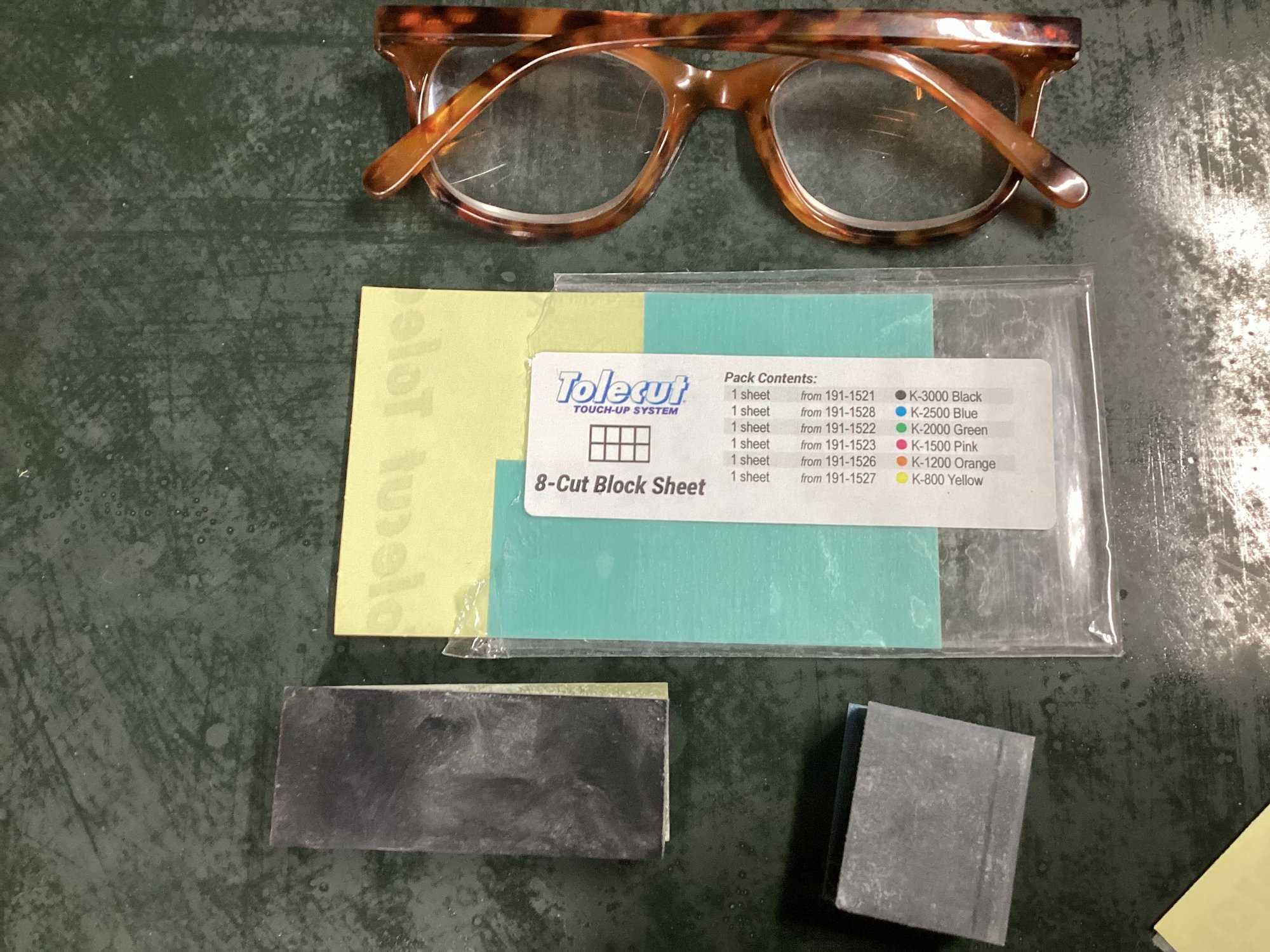 Here�s the Kovax system. The sanding blocks are very small and the paper is precut to fit each block. There is a small curved block (not shown) and a Tolecard which has the size and flexibility of a playing card so it works best on most of the body panel curves. 