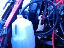return line stuck into a milk jug to catch excess and old fluid being purged from the system