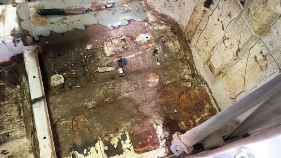 drivers side under seat area in process of cleaning removing factory sound deadener (tar)
