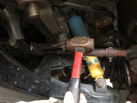 use a brass hammer and impact the flat spot on the linkage to jar it loose.  