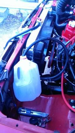 return line stuck into a milk jug to catch excess and old fluid being purged from the system