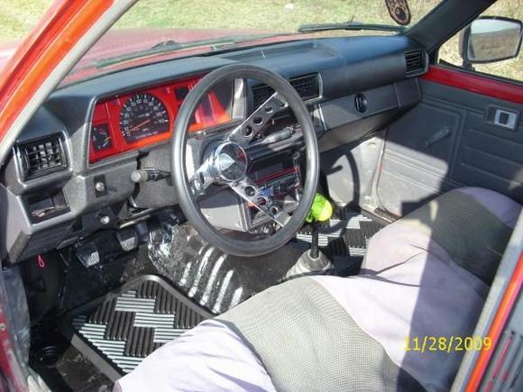 my redone interior, racing style steering wheel, painted dash, painted cluster, tore out the flooring and replaced with diy spray in bedliner, and cool little grn skull shifter knob